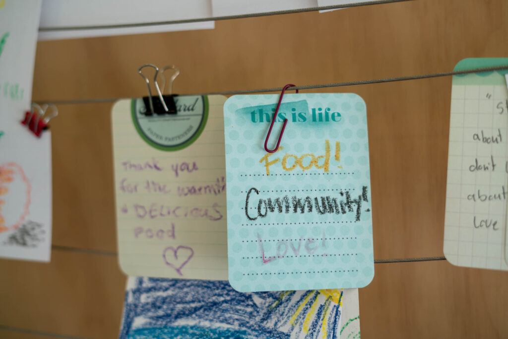 Cards on a line display messages including "Food! Community! Love!"